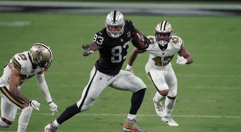 Las Vegas Raiders tight end Darren Waller (83) runs the ball against New Orleans Saints cornerback Marshon Lattimore (23) and free safety Marcus Williams (43) during the fourth quarter of a NFL game at Allegiant Stadium