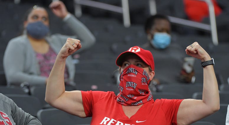 A UNLV Rebels fan flexes for the camera during a time out between the UNLV Rebels and the Fresno Bulldogs at Allegiant Stadium.