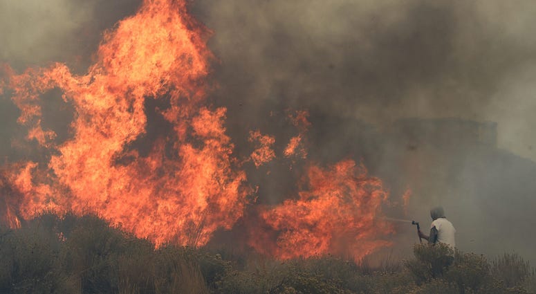 Homeowner Steven Phelps battles the Pinehaven Fire in the Caughlin Ranch area of Reno on Nov. 17, 2020.