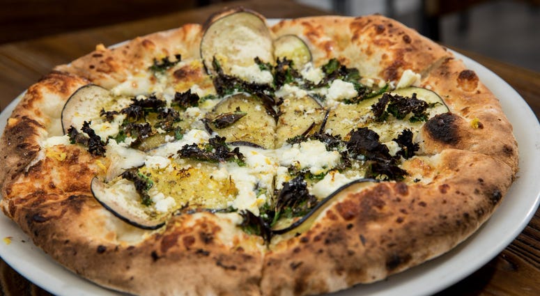 Eggplant, kale, sheep’s milk cheese, lemon and za'atar pizza at Stina. Stina restaurant