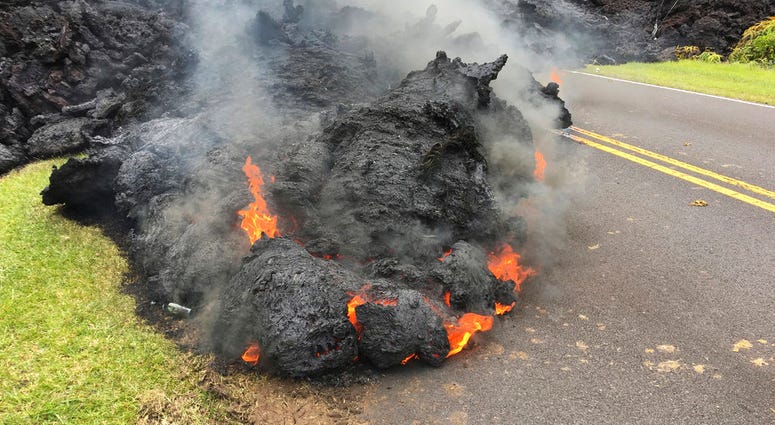 Lava from the Kilauea volcano moves across the road in the Leilani Estates in Pahoa, Hawaii, Saturday, May 5, 2018. Hawaii Volcano