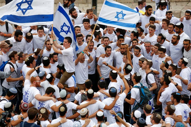 Israeli youths wave national flags outside the Old City's Damascus Gate. Israeli youths wave national flags outside the Old City's Damascus Gate.