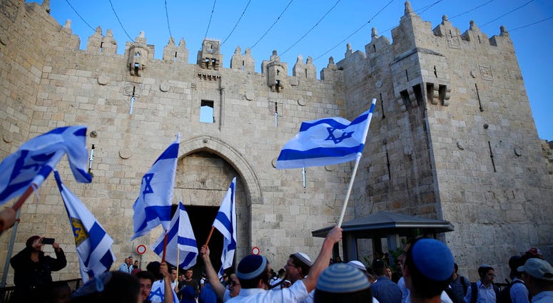 Israelis wave national flags outside the Old City's Damascus Gate. Israelis wave national flags outside the Old City's Damascus Gate.