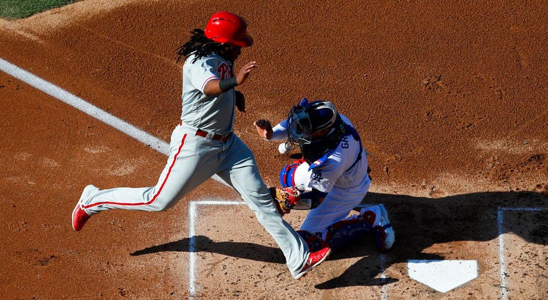 Philadelphia Phillies' Maikel Franco, right, scores on a single by Jorge Alfaro as Los Angeles Dodgers catcher Yasmani Grandal misses the throw during the second inning. Philadelphia Phillies' Maikel Franco, right, scores on a single by Jorge Alfaro as Los Angeles Dodgers catcher Yasmani Grandal misses the throw during the second inning.