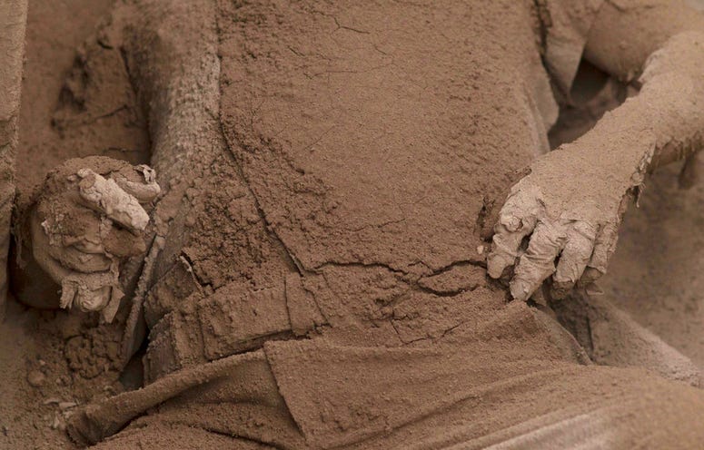 The body of a victim is covered in volcanic ash spewed by the Volcan de Fuego. The body of a victim is covered in volcanic ash spewed by the Volcan de Fuego.