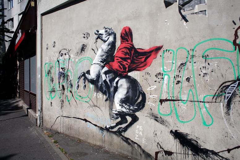 A graffiti believed to be attributed to street artist Banksy is seen on a wall along a street in Paris. A graffiti believed to be attributed to street artist Banksy is seen on a wall along a street in Paris.