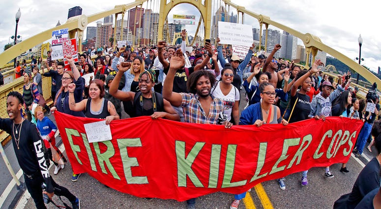 In this June 22, 2018, file photo, demonstrators protesting the fatal police shooting of Antwon Rose Jr. cross the Roberto Clemente Bridge during an evening rush hour march that began in downtown Pittsburgh. In this June 22, 2018, file photo, demonstrators protesting the fatal police shooting of Antwon Rose Jr. cross the Roberto Clemente Bridge during an evening rush hour march that began in downtown Pittsburgh.
