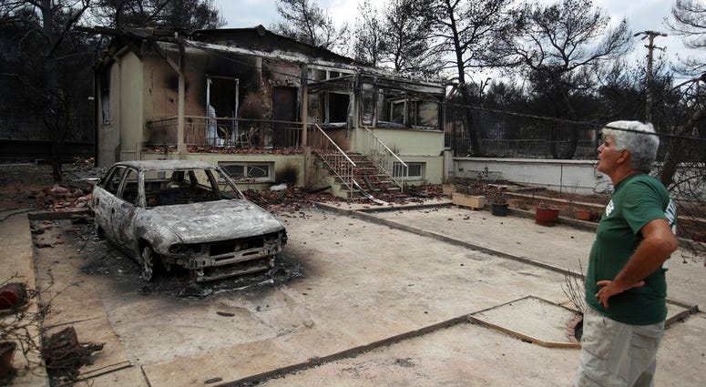 A man looks the burned house of his sister in Agios Andreas, east of Athens, Tuesday, July 24, 2018. A man looks the burned house of his sister in Agios Andreas, east of Athens, Tuesday, July 24, 2018.