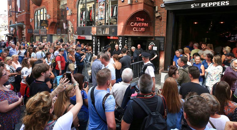 People queue outside the Cavern Club in Liverpool, England, before an exclusive gig by former Beatles member Paul McCartney, Thursday July 26, 2018. People queue outside the Cavern Club in Liverpool, England, before an exclusive gig by former Beatles member Paul McCartney, Thursday July 26, 2018.