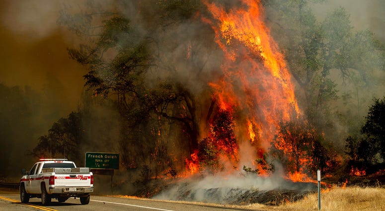 Flames from the Carr Fire lick above a Cal Fire truck in Whiskeytown, Calif., on Friday, July 27, 2018. Flames from the Carr Fire lick above a Cal Fire truck in Whiskeytown, Calif., on Friday, July 27, 2018.