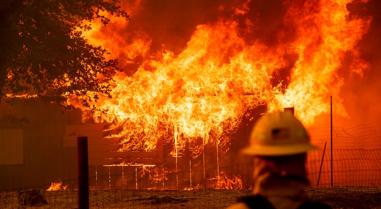 A firefighter monitors a burning outbuilding to ensure flames don't spread as the River Fire burns in Lakeport, Calif., on Monday, July 30, 2018. A firefighter monitors a burning outbuilding to ensure flames don't spread as the River Fire burns in Lakeport, Calif., on Monday, July 30, 2018.
