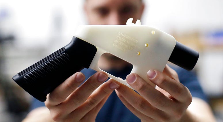 In this Aug. 1, 2018, file photo, Cody Wilson, with Defense Distributed, holds a 3D-printed gun called the Liberator at his shop in Austin, Texas. 3D-printed gun