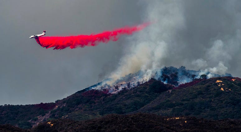 A plane drops fire retardant as firefighters continue to battle a wildfire in the Cleveland National Forest near Corona, Calif. on Tuesday, Aug. 7, 2018. A plane drops fire retardant as firefighters continue to battle a wildfire in the Cleveland National Forest near Corona, Calif. on Tuesday, Aug. 7, 2018.