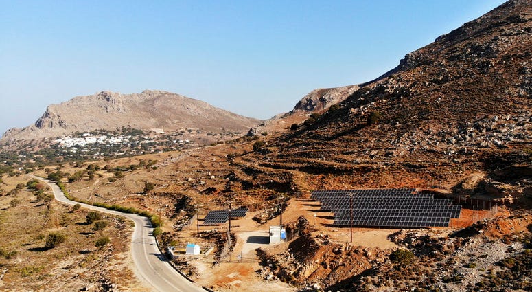In this Thursday, Aug. 9, 2018, photo a road leads past a solar park on the Aegean island of Tilos, Greece. In this Thursday, Aug. 9, 2018, photo a road leads past a solar park on the Aegean island of Tilos, Greece.