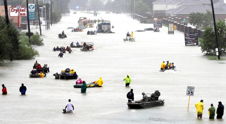 In this Aug. 28, 2017 file photo, rescue boats fill a flooded street as flood victims are evacuated as floodwaters from Tropical Storm Harvey rise in Houston. In this Aug. 28, 2017 file photo, rescue boats fill a flooded street as flood victims are evacuated as floodwaters from Tropical Storm Harvey rise in Houston.