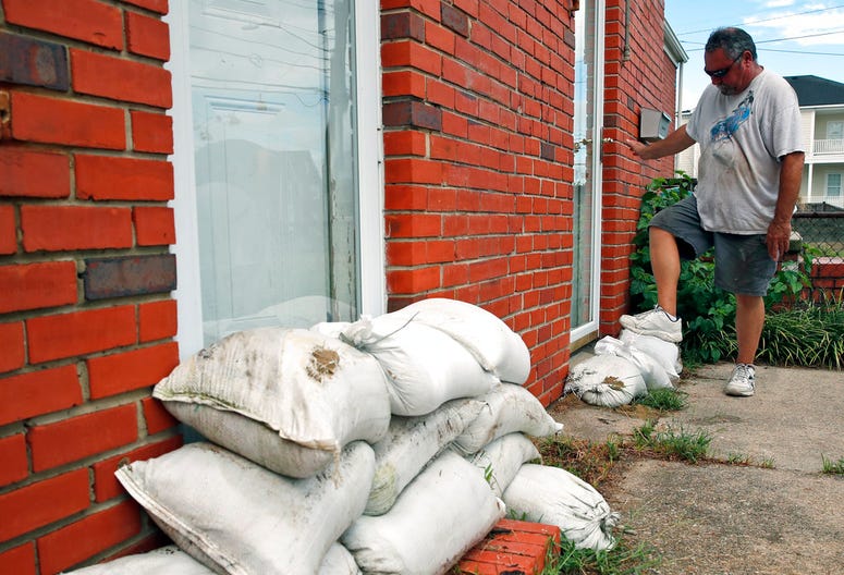 Adam Bazemore uses his foot to pack down sandbags in a doorway, Tuesday, Sept. 11, 2018, in the Willoughby Spit area of Norfolk, Va., as he makes preparations for Hurricane Florence. Adam Bazemore uses his foot to pack down sandbags in a doorway, Tuesday, Sept. 11, 2018, in the Willoughby Spit area of Norfolk, Va., as he makes preparations for Hurricane Florence.