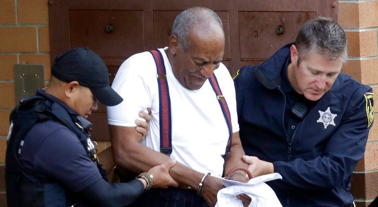 FILE - In a Tuesday Sept. 25, 2018 file photo, Bill Cosby is escorted out of the Montgomery County Correctional Facility, in Eagleville, Pa., following his sentencing to three-to-10-year prison sentence for sexual assault. Bill Cosby