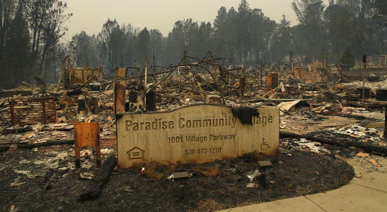 A sign stands at a community destroyed by the Camp fire, Tuesday, Nov. 13, 2018, in Paradise, Calif.