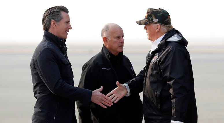 President Trump greets California Gov.-elect Gavin Newsom as he arrives on Air Force One at Beale Air Force Base for a visit to areas impacted by the wildfires as Gov. Jerry Brown stands at attention. President Donald Trump