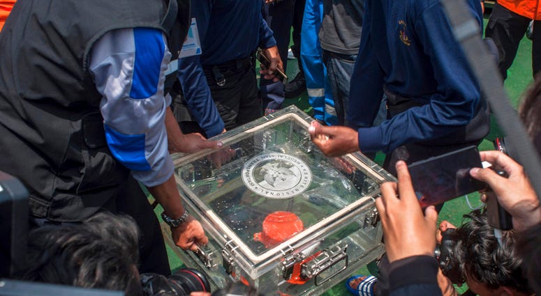 FILE - In this Thursday, Nov. 1, 2018, file photo, members of the National Transportation Safety Committee lift a box containing the flight data recorder from a crashed Lion Air jet onboard a rescue ship anchored in the waters of Tanjung Karawang, Indones FILE - In this Thursday, Nov. 1, 2018, file photo, members of the National Transportation Safety Committee lift a box containing the flight data recorder from a crashed Lion Air jet onboard a rescue ship anchored in the waters of Tanjung Karawang, Indones