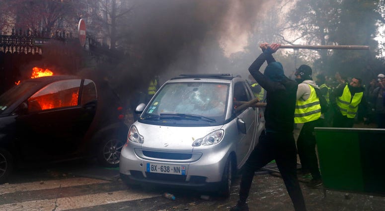 Hooded demonstrators smash a car during a demonstration Saturday, Dec.1, 2018 in Paris. Hooded demonstrators smash a car during a demonstration Saturday, Dec.1, 2018 in Paris.
