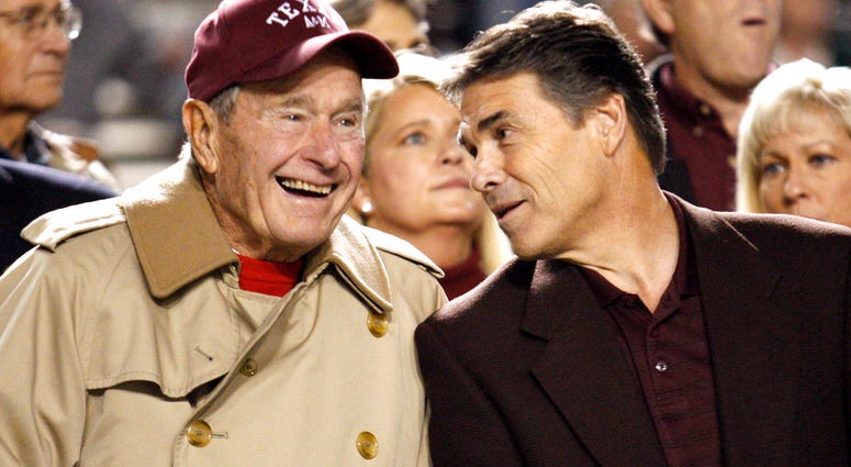 FILE - In this Nov. 26, 2009, file photo, former President George H.W. Bush, left, talks with Texas Gov. Rick Perry before an NCAA college football game between Texas and Texas A&M, in College Station, Texas. FILE - In this Nov. 26, 2009, file photo, former President George H.W. Bush, left, talks with Texas Gov. Rick Perry before an NCAA college football game between Texas and Texas A&M, in College Station, Texas.