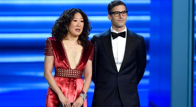 FILE - In this Sept. 17, 2018 file photo, Sandra Oh, left, and Andy Samberg present an award at the 70th Primetime Emmy Awards in Los Angeles. FILE - In this Sept. 17, 2018 file photo, Sandra Oh, left, and Andy Samberg present an award at the 70th Primetime Emmy Awards in Los Angeles.