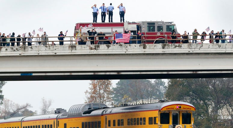 Firefighters stand on their truck and salute along with other attendants on an overpass as the train carrying the body of former president George H.W. Bush travels past on the way to Bush's final internment Thursday, Dec. 6, 2018, in Spring, Texas. Firefighters stand on their truck and salute along with other attendants on an overpass as the train carrying the body of former president George H.W. Bush travels past on the way to Bush's final internment Thursday, Dec. 6, 2018, in Spring, Texas.
