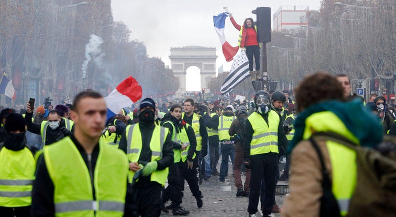 In this Nov. 24, 2018, file photo, demonstrators march on the famed Champs-Elysees avenue in Paris, France, as they protest the rising of the fuel prices. In this Nov. 24, 2018, file photo, demonstrators march on the famed Champs-Elysees avenue in Paris, France, as they protest the rising of the fuel prices.