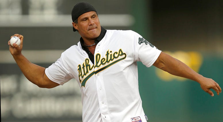 In this Sept. 3, 2016, file photo, former Oakland Athletics player Jose Canseco throws out the ceremonial first pitch prior to a baseball game against the Boston Red Sox in Oakland, Calif. Former Oakland Athletics player Jose Canseco