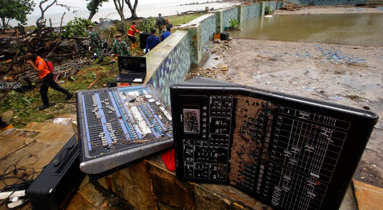 A rescue team walks near an audio mixer damaged by a tsunami at Tanjung Lesung beach resorts Indonesia, Monday, Dec. 24, 2018. A rescue team walks near an audio mixer damaged by a tsunami at Tanjung Lesung beach resorts Indonesia, Monday, Dec. 24, 2018.