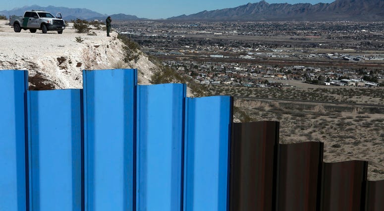 FILE - In this Jan. 25, 2017, file photo, an agent from the border patrol, observes near the Mexico-US border fence, on the Mexican side, separating the towns of Anapra, Mexico and Sunland Park, N.M. FILE - In this Jan. 25, 2017, file photo, an agent from the border patrol, observes near the Mexico-US border fence, on the Mexican side, separating the towns of Anapra, Mexico and Sunland Park, N.M.