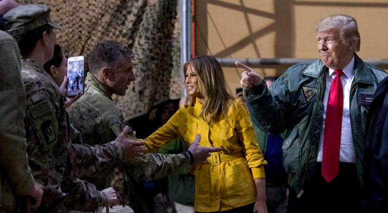 President Donald Trump and first lady Melania Trump greet members of the military as they arrive for a hangar rally at Al Asad Air Base, Iraq, Wednesday, Dec. 26, 2018. President Donald Trump and first lady Melania Trump greet members of the military as they arrive for a hangar rally at Al Asad Air Base, Iraq, Wednesday, Dec. 26, 2018.