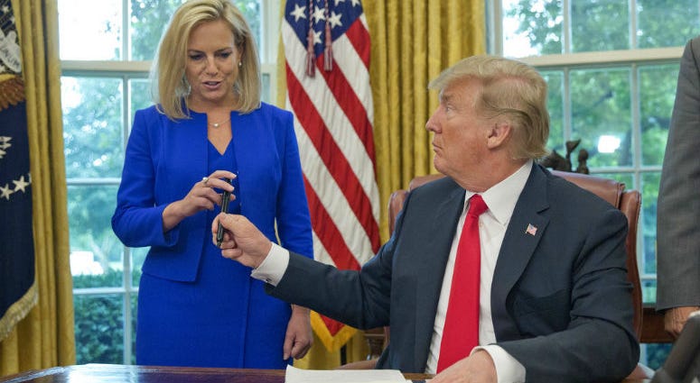FILE - In this Wednesday, June 20, 2018 file photo, President Donald Trump gives the pen he used to sign the executive order to end family separations to Homeland Security Secretary Kirstjen Nielsen, left, during an event in the Oval Office of the White H FILE - In this Wednesday, June 20, 2018 file photo, President Donald Trump gives the pen he used to sign the executive order to end family separations to Homeland Security Secretary Kirstjen Nielsen, left, during an event in the Oval Office of the White H