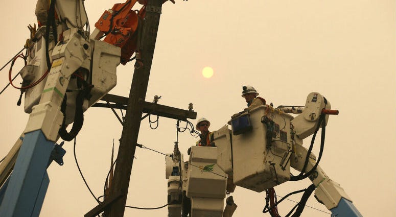 FILE - In this Nov. 9, 2018 file photo, Pacific Gas & Electric crews work to restore power lines in Paradise, Calif. FILE - In this Nov. 9, 2018 file photo, Pacific Gas & Electric crews work to restore power lines in Paradise, Calif.