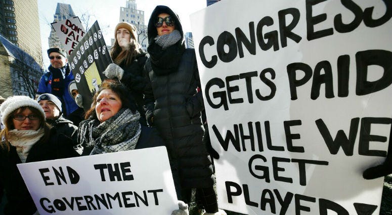 Government workers and their supporters hold signs during a protest in Boston. government shutdown