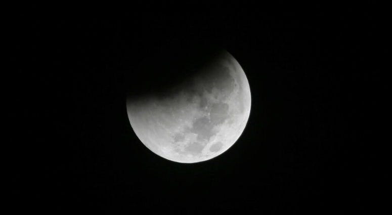 FILE - In this Saturday Aug. 28, 2018 file photo, Earth starts to cast its shadow on the moon during a complete lunar eclipse seen from Jakarta, Indonesia. FILE - In this Saturday Aug. 28, 2018 file photo, Earth starts to cast its shadow on the moon during a complete lunar eclipse seen from Jakarta, Indonesia.