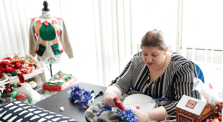 Doris Cochran works on "an ugly sweater," which she is planning to sell. Cochran is a disabled mother of two young boys living in subsidized housing. She’s stockpiling canned foods to ensure her family won’t go hungry if her food stamps run out. Doris Cochran works on "an ugly sweater," which she is planning to sell. Cochran is a disabled mother of two young boys living in subsidized housing. She’s stockpiling canned foods to ensure her family won’t go hungry if her food stamps run out.