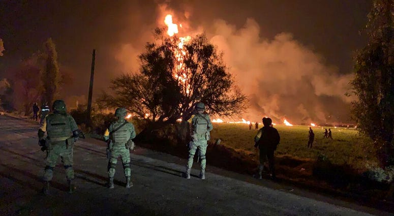 In this image provided by the Secretary of National Defense, soldiers guard the area by an oil pipeline explosion in Tlahuelilpan, Hidalgo state, Mexico, Friday, Jan. 18, 2019. mexico explosion
