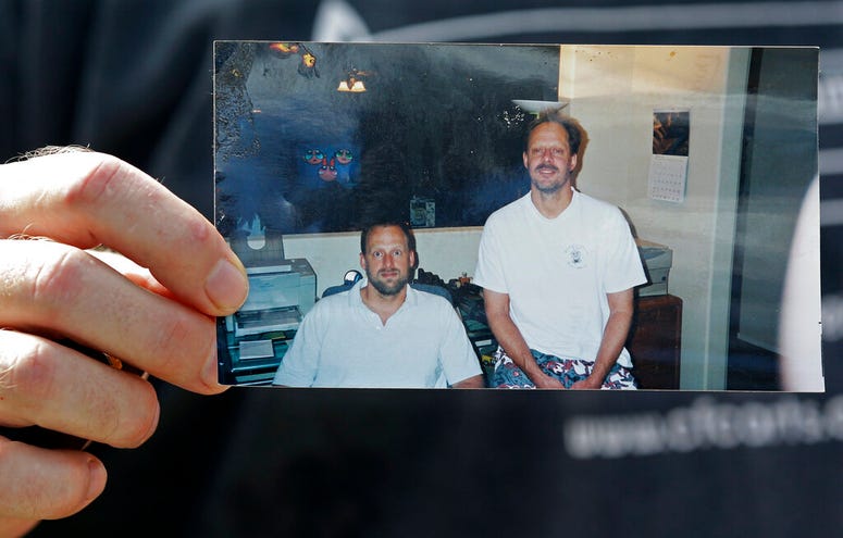 In this Oct. 2, 2017 file photo, Eric Paddock holds a photo of himself, at left, and his brother, Stephen Paddock, at right, outside his home in Orlando, Fla. In this Oct. 2, 2017 file photo, Eric Paddock holds a photo of himself, at left, and his brother, Stephen Paddock, at right, outside his home in Orlando, Fla.