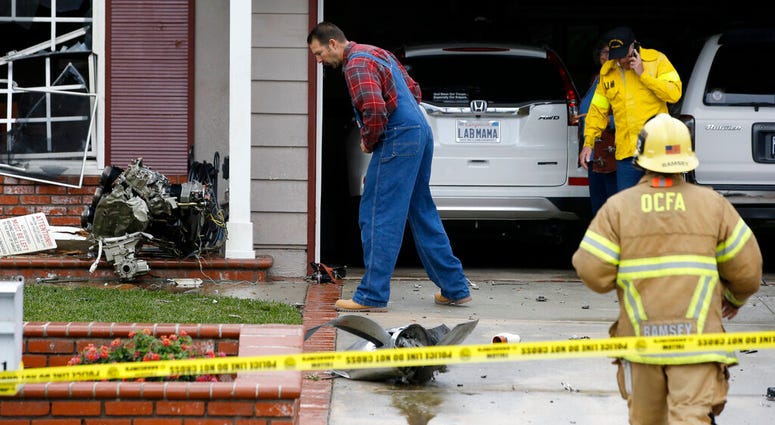 A resident looks at debris that hit a house after a small plane crashed into a neighborhood of Yorba Linda, Calif., Sunday, Feb. 3, 2019. A resident looks at debris that hit a house after a small plane crashed into a neighborhood of Yorba Linda, Calif.