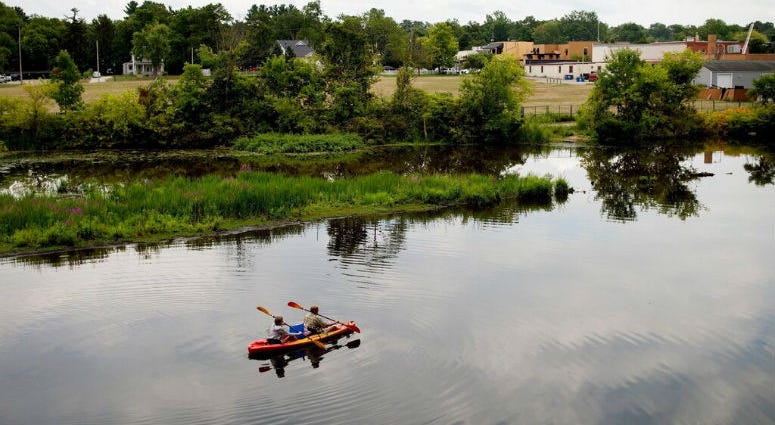 ILE- In this Aug. 14, 2017 file photo, a couple kayak on the Rogue River adjacent to where Wolverine World Wide's tannery once stood, in Rockford, Mich. ILE- In this Aug. 14, 2017 file photo, a couple kayak on the Rogue River adjacent to where Wolverine World Wide's tannery once stood, in Rockford, Mich.