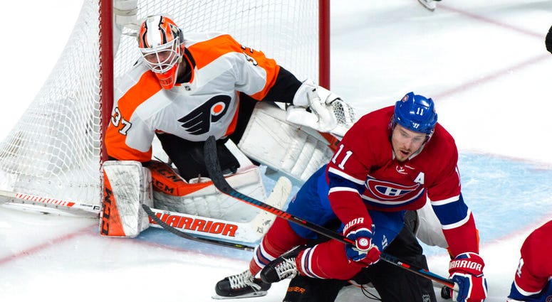 Montreal Canadiens' Brendan Gallagher falls over Philadelphia Flyers defenceman Robert Hagg in front of goaltender Brian Elliott during the third period of an NHL hockey game Thursday, Feb. 21, 2019, in Montreal. Flyers