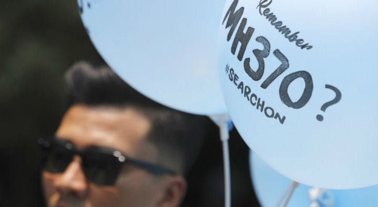A volunteer gives out balloons printed with MH370 during a Day of Remembrance for MH370 event in Kuala Lumpur, Malaysia, Sunday, March 3, 2019. A volunteer gives out balloons printed with MH370 during a Day of Remembrance for MH370 event in Kuala Lumpur, Malaysia, Sunday, March 3, 2019.