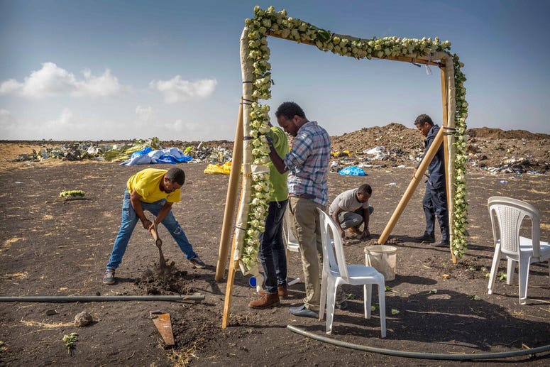 Workers erect floral installations at the scene where the Ethiopian Airlines Boeing 737 Max 8 crashed shortly after takeoff on Sunday killing all 157 on board, near Bishoftu, or Debre Zeit, south of Addis Ababa, in Ethiopia Wednesday, March 13, 2019. Workers erect floral installations at the scene where the Ethiopian Airlines Boeing 737 Max 8 crashed.