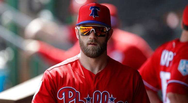 In this March 9, 2019 file photo Philadelphia Phillies' Bryce Harper waits his turn in the batting cage before a spring training baseball game against the Toronto Blue Jays in Clearwater, Fla. Bryce Harper