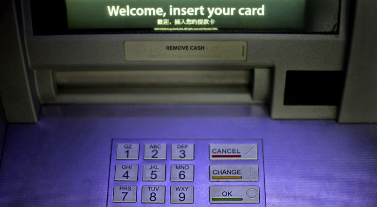 FILE - In this Tuesday, July 16, 2013, file photo, an ATM is displayed at a Wells Fargo bank, in Atlanta. An ATM is displayed at a Wells Fargo bank, in Atlanta.