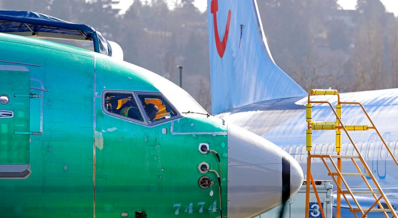 In this March 13, 2019, file photo a worker walks past an engine on a Boeing 737 MAX 8 airplane being built for American Airlines at Boeing Co.'s Renton assembly plant in Renton, Wash. An engine on a Boeing 737 MAX 8 airplane.