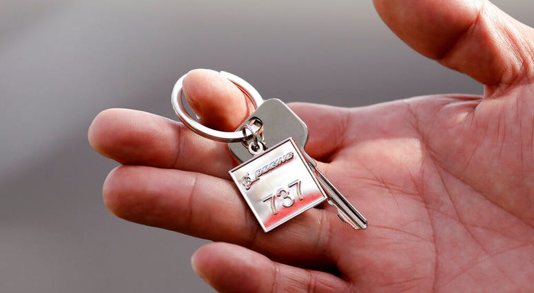 A Thai Lion Air employee displays a ceremonial key to the company's newest plane, Boeing's first 737 MAX 9 jet, following a delivery ceremony to the airline in Seattle. A Thai Lion Air employee displays a ceremonial key to the company's newest plane, Boeing's first 737 MAX 9 jet.