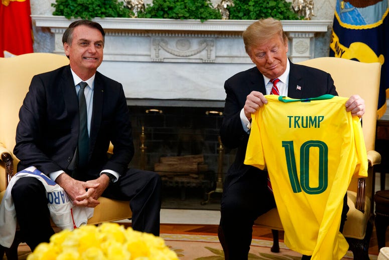 Brazilian President Jair Bolsonaro presents President Donald Trump with a Brazilian national team soccer jersey in the Oval Office of the White House, Tuesday, March 19, 2019, in Washington. Brazilian President Jair Bolsonaro and President Donald Trump
